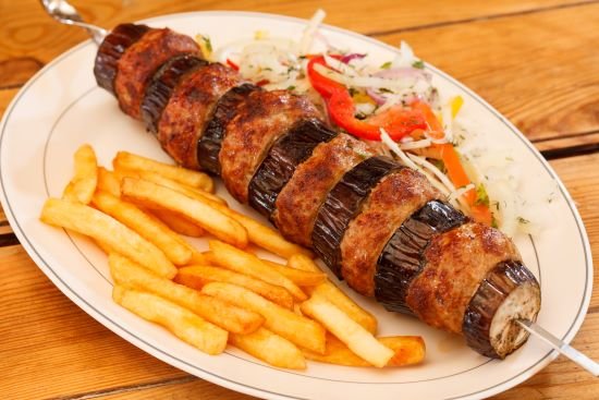 An-meat-and-eggplant-kebab-with-french-fries-on-a-plate